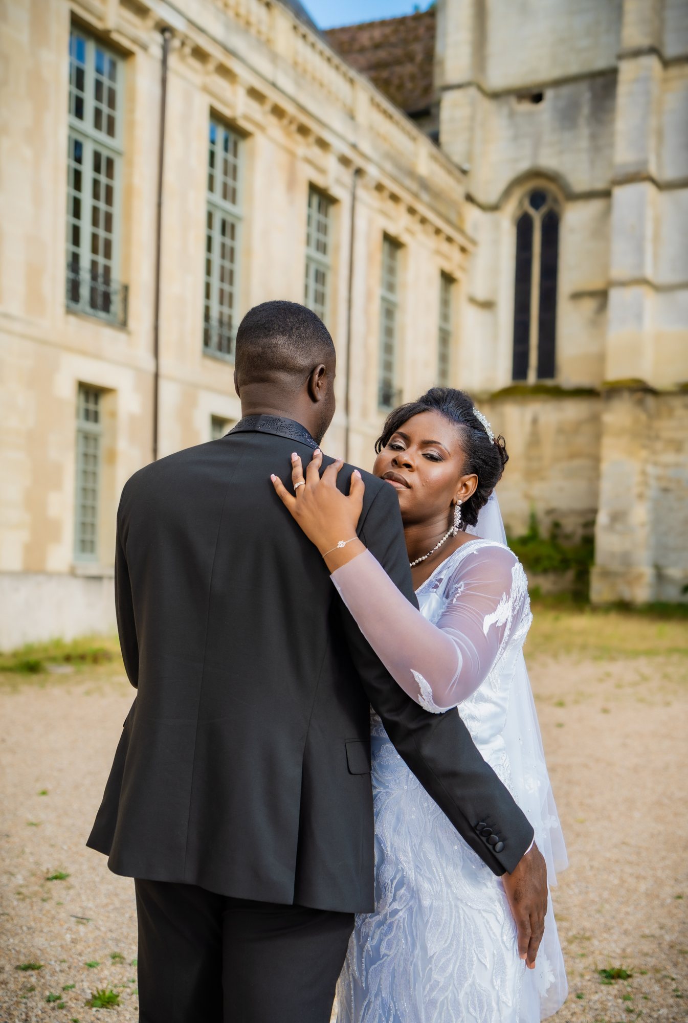 Mariée au regard intense, la main posée sur l’épaule de son mari